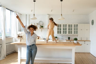 mom and daughter dancing in kitchen